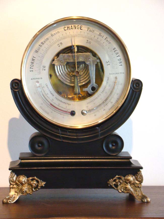A fine 19th century Aneroid Barometer on a custom made black lacquered stand with gilt ormolu feet circa 1850.